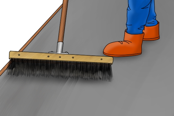 Brushing concrete with broom