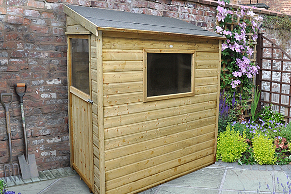 Small pent shed against wall