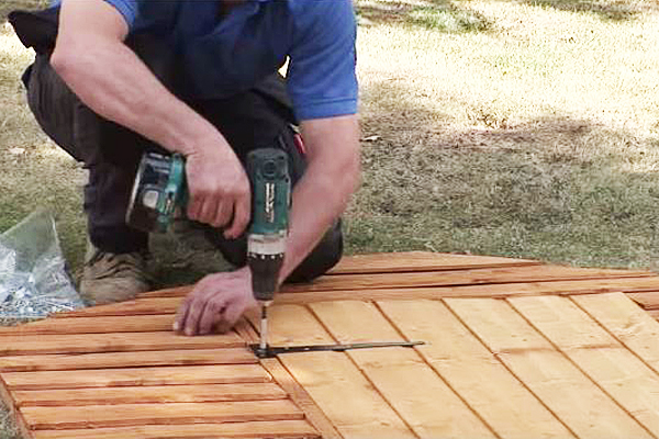 Screwing hinges onto shed door